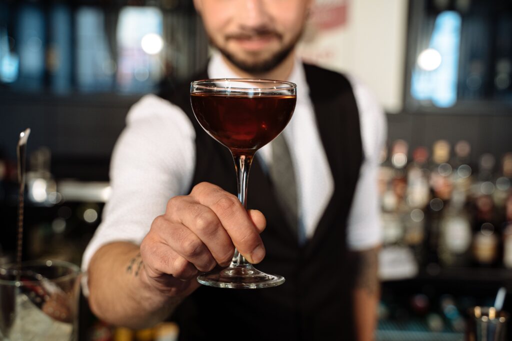 Bartender entregando un cóctel en la barra